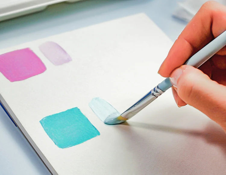 A person using a brush to paint abstract shapes in shades of blues and pinks using Sculpd Canvas Painting Kit 