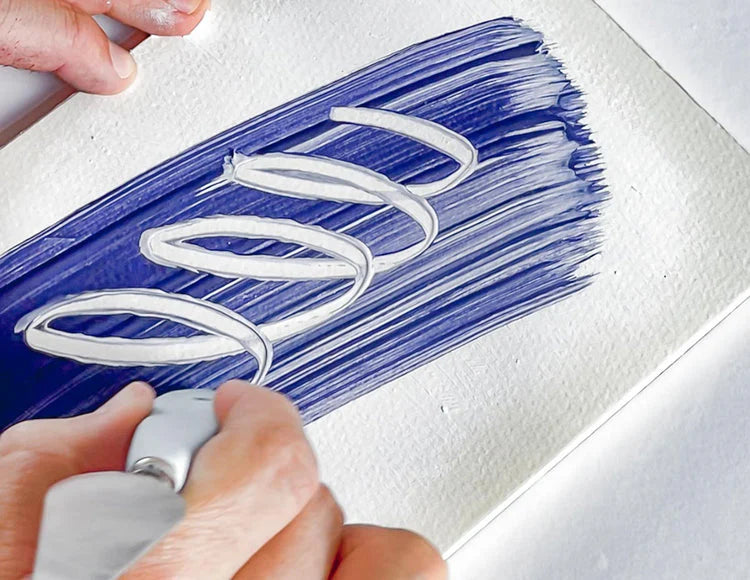 A person using a Palette knife to trace shapes over a painting on a canvas on a table