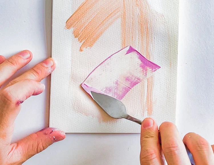 Hands using a palette knife to paint a canvas with abstract shapes using Sculpd Canvas Painting Kit