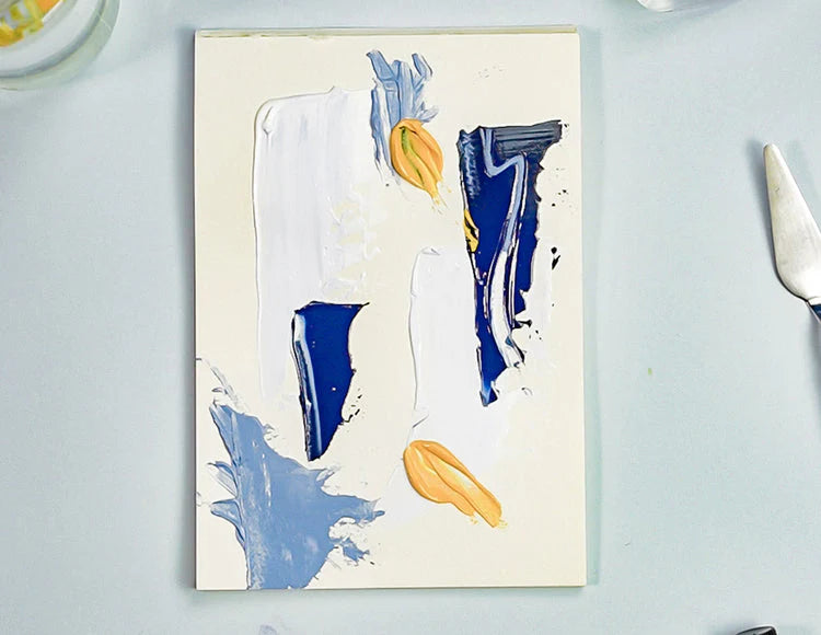Abstract painting in shades of yellows and blues displayed on a table made using Sculpd Canvas Painting Kit 